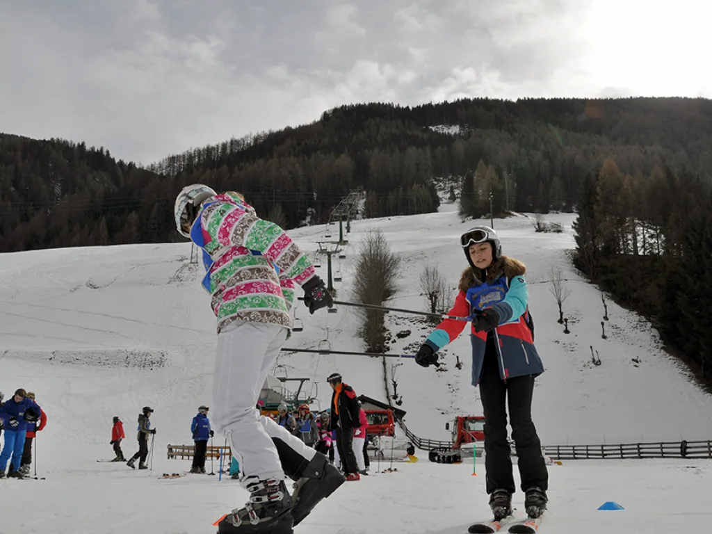 Snowboarderin richtet sich auf, daneben eine weitere Person.